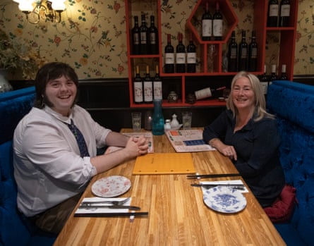 Lucas and Marie-Rose sitting opposite one another chatting at a restaurant table