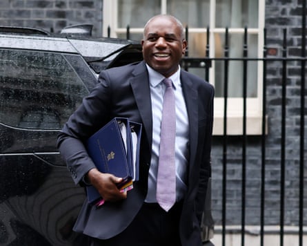 Lammy walks away from a car, clutching binders full of papers