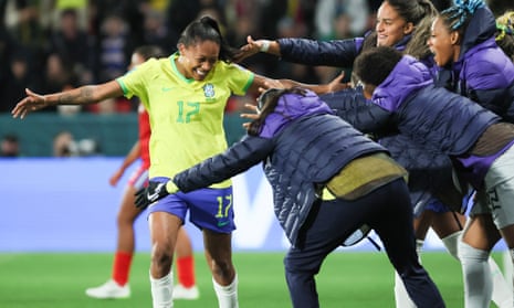 Ary Borges dari Brasil bereaksi dengan rekan setimnya di bangku cadangan setelah mencetak gol kedua timnya.