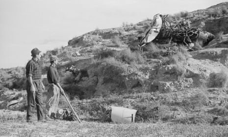 Spanish workmen look at wreckage scattered over a hillside as they assist in the search for a missing hydrogen bomb in January 1966