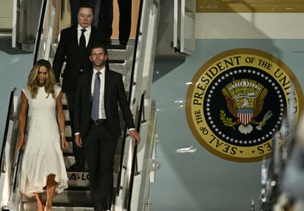 Eric and Lara Trump and Elon Musk walk off Air Force One upon arriving in Beijing.