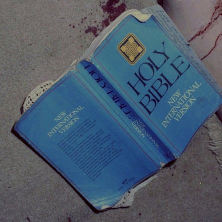 A blue Bible on the floor next to some blood