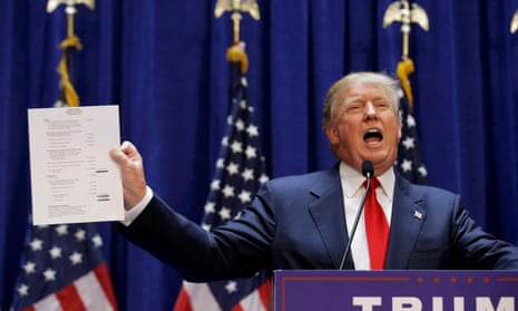 Donald Trump holds up his financial statement after declaring his candidacy for US president.