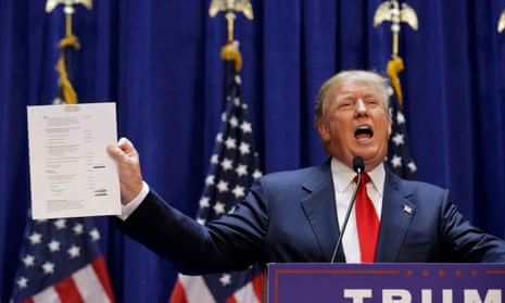 Donald Trump holds up his financial statement showing his net worth as he formally announces his campaign for the 2016 Republican presidential nomination at Trump Tower in New York on 16 June 2015.