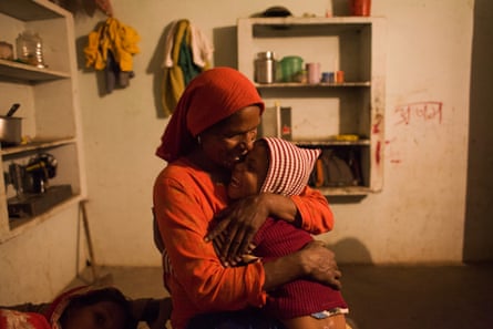 Saeeda hugs and kisses her 5 years old daughter in their home in Mewat District, Haryana, India