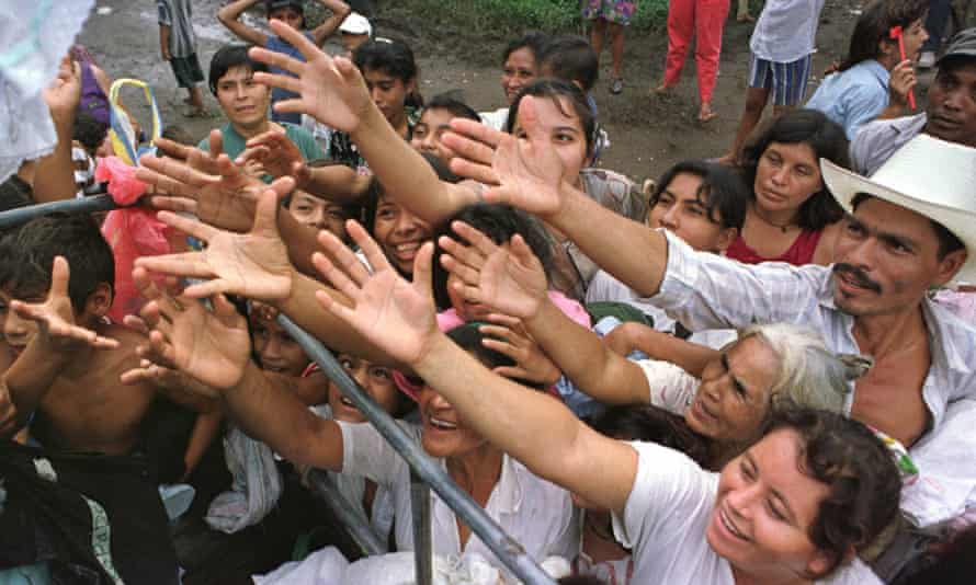 People in San Carlos, El Salvador, reach out for aid in the aftermath of Hurricane Mitch in 1998.
