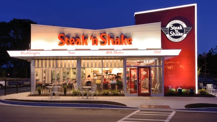An exterior of Steak ‘n Shake diner lit up at night