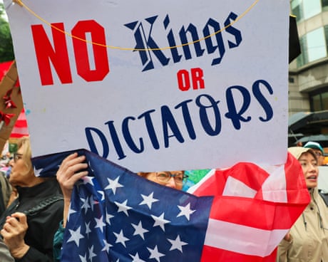a person holds a US flag and a sign that reads 'no kings or dictators'