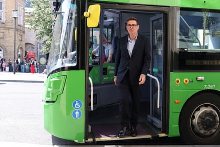Andy Burnham steps off a bright green bus in central Bath.