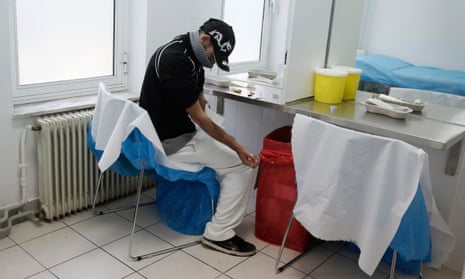 A drug user cleans his arm at a supervised injection site in central Athens.