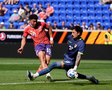 Ché Adams forces a shot underneath the legs of the Bolivia keeper