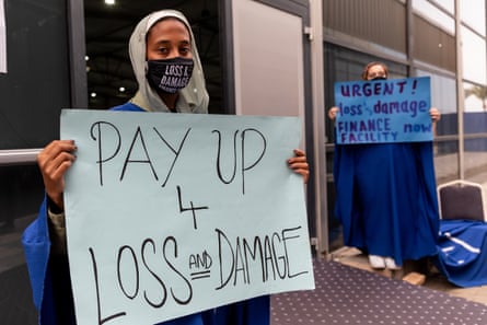 Protesters holding up signs asking for a loss and damage fund, at Cop27 in Egypt, November 2022