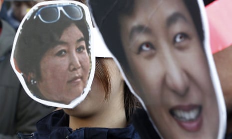 Masks mocking Park Geun-hye, right, and Choi Soon-sil at a protest rally in Seoul.