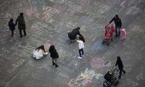 People write messages on the ground at Place de la Bourse, a square outside the Brussels stock exchange.