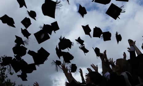 Students throw their mortarboards in the air during their graduation photograph