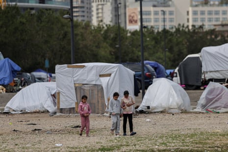 Children walk in a temporary encampment for displaced people in the Lebanese capital of Beirut amid the Israeli war which has forced hundreds of thousands of people from their homes.