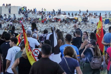 Crowds of protesters facing dozens of people on the beach