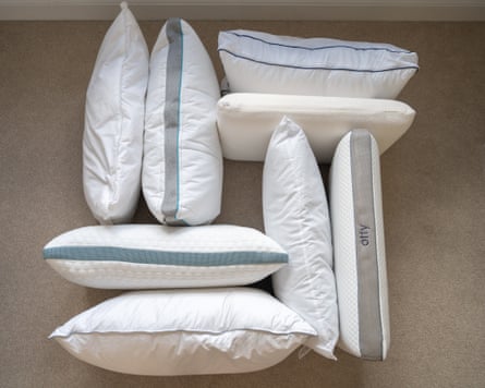 Group shot of eight pillows, unboxed and unbagged, on a carpeted floor.