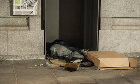 homeless person lying down in a doorway
