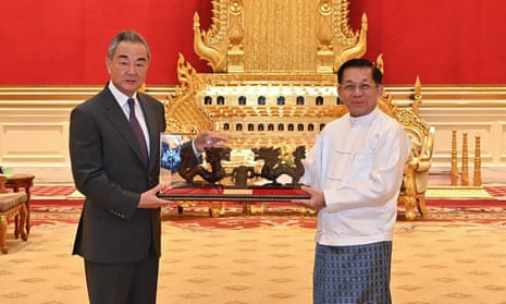 Wang Yi in a suit and tie, and Min Aung Hlaing in a white jacket, inside the presidential palace in Naypyidaw.