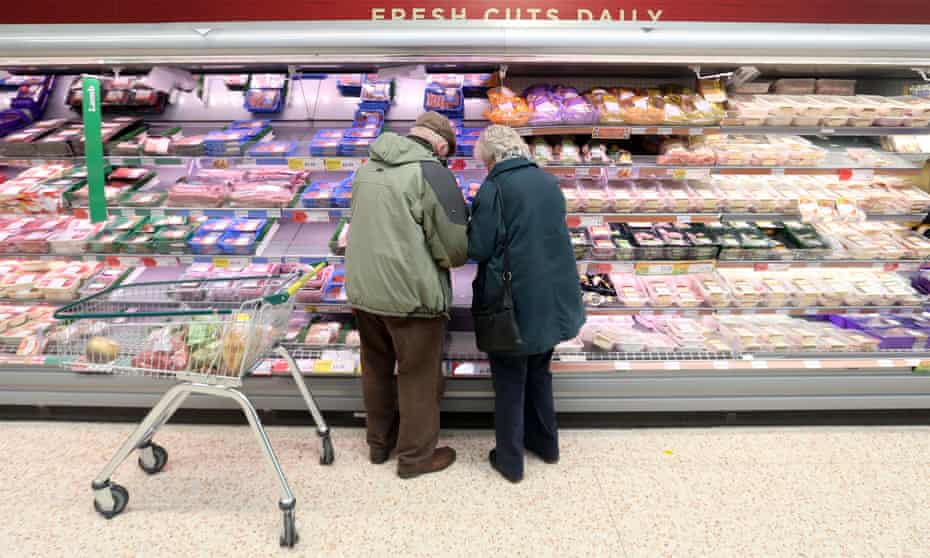 Shoppers looking at meat packing in supermarket