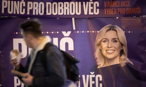 A man walks past a campaign poster for Danuše Nerudová, the only woman among the eight candidates and one of the frontrunners.