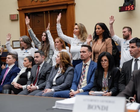 a group of people stand up and raise hands
