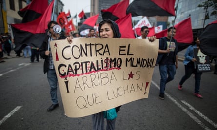 A demonstrator in Lima against the IMF and World Bank meetings holds a banner that says: ‘Against world capitalism. Long live those who fight.’