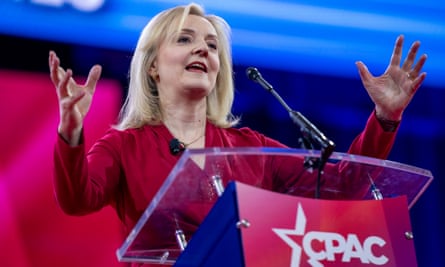 Truss raises her hands while speaking at a CPAC-branded lectern