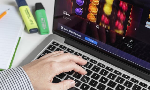 Person at a computer keyboard playing fruit machine slots