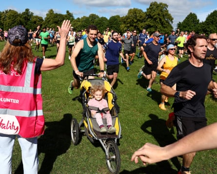 A man with a buggy runs among a crowd.