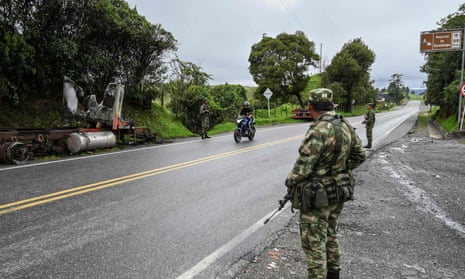 Colombian soldiers stand guard next to a truck burnt by members of the Gulf clanc, on a road near Yarumal, Antioquia department.