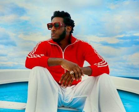 Leon Bridges wear a red tracksuit and wide-legged white trousers