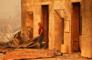 Resident inspects burned out building.