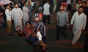 A man carries an injured child to the hospital in Lahore after the bombing.