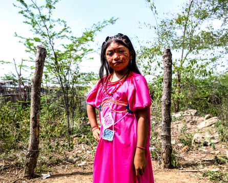 Luz Neida Elena, 10, standing outdoors in a pink dress.