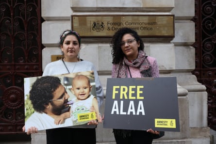 Two women hold up a photograph and sign saying ‘free Alaa’ outside the foreign office