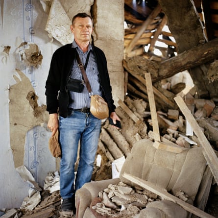 A man standing amid rubble in a building