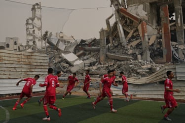 Football players in front of destroyed buildings