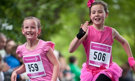 two young girls running to raise money for cancer research charity