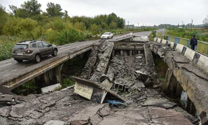Cars cross a damaged bridge in Kharkiv, Ukraine.