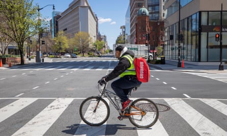 A Grubhub delivery person makes bicycle deliveries on the empty streets of Washington DC.
