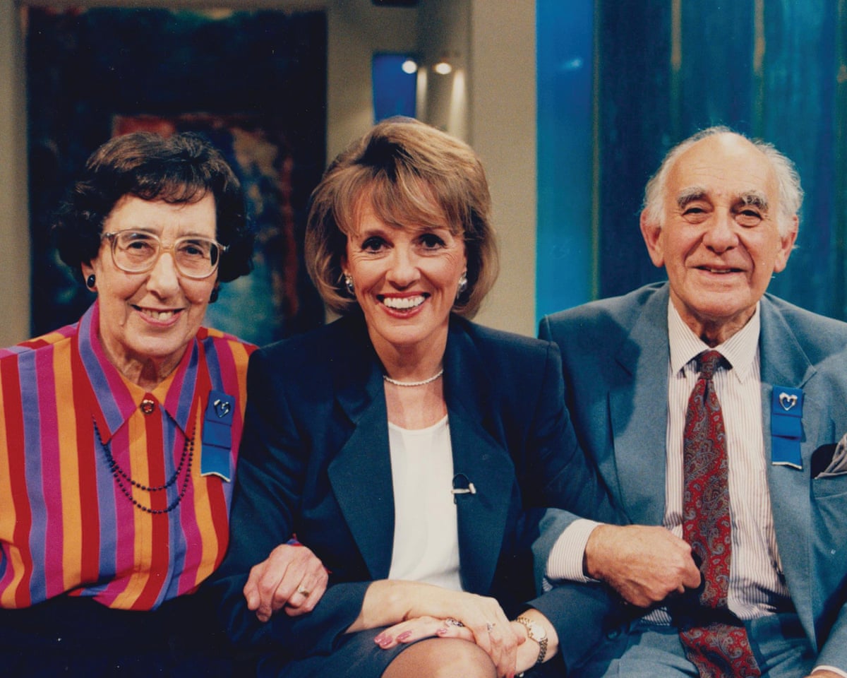 Esther Rantzen sitting between two people, all linking arms