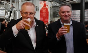 Scott Morrison and finance minister Mathias Cormann drink a beer to announce a budget tax cut on small kegs. 