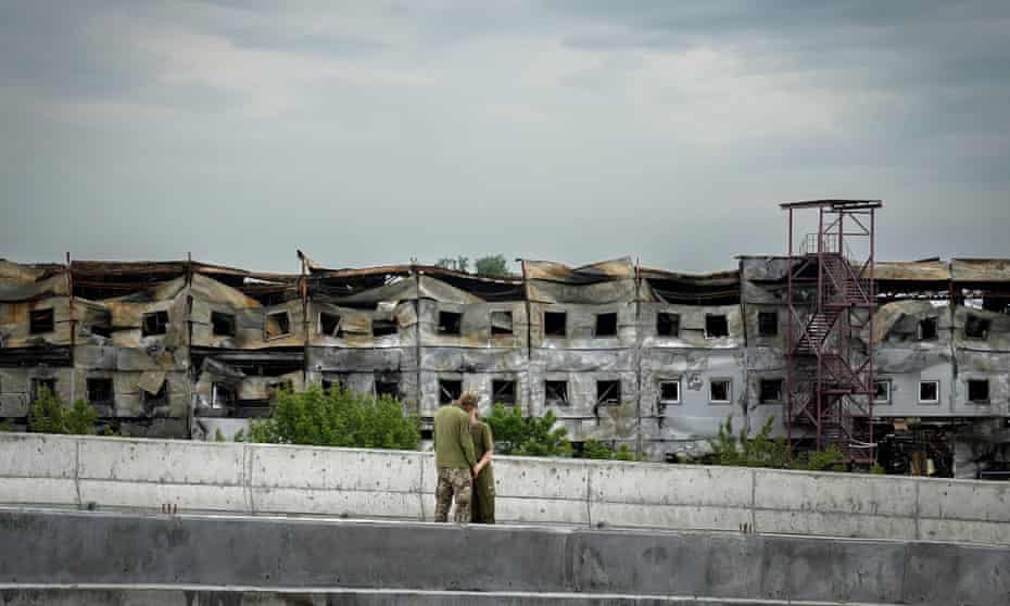 Two Ukrainian soldiers enjoy a tender off-duty moment near the village of Stoyanka in Kyiv, Ukraine.