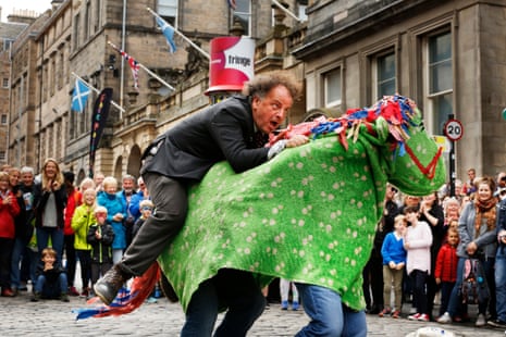 Performer Herbie Treehead gets the public to volunteer to be his pantomime horse on the Royal Mile.