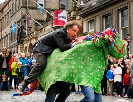 Performer Herbie Treehead gets the public to volunteer to be his pantomime horse on the Royal Mile