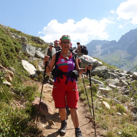 Rita Schirmer-Braun camina por un sendero de montaña seguida de otros caminantes.