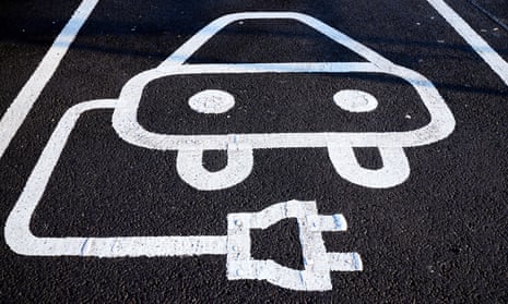 an EV charging zone sign painted on the road