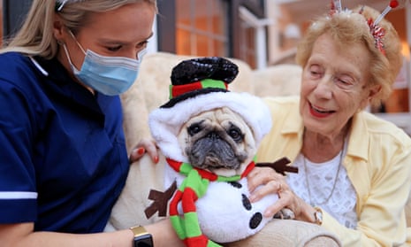 Cicely, a resident at Eridge House care home in Bexhill, East Sussex, with a staff member and pug